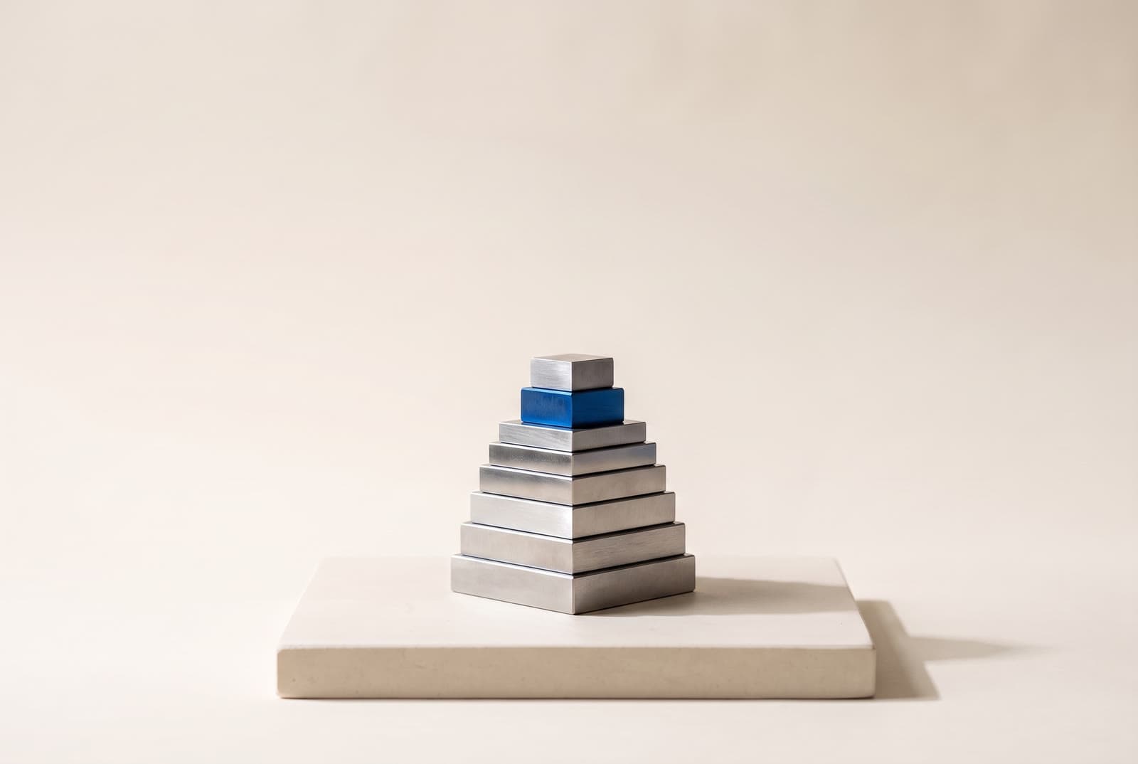 A stepped stack of polished steel gauge blocks with one cobalt block